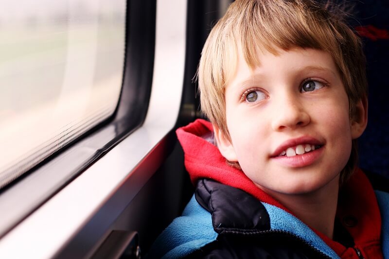 Chłopiec z Zespołem Aspergera patrzący przez okno