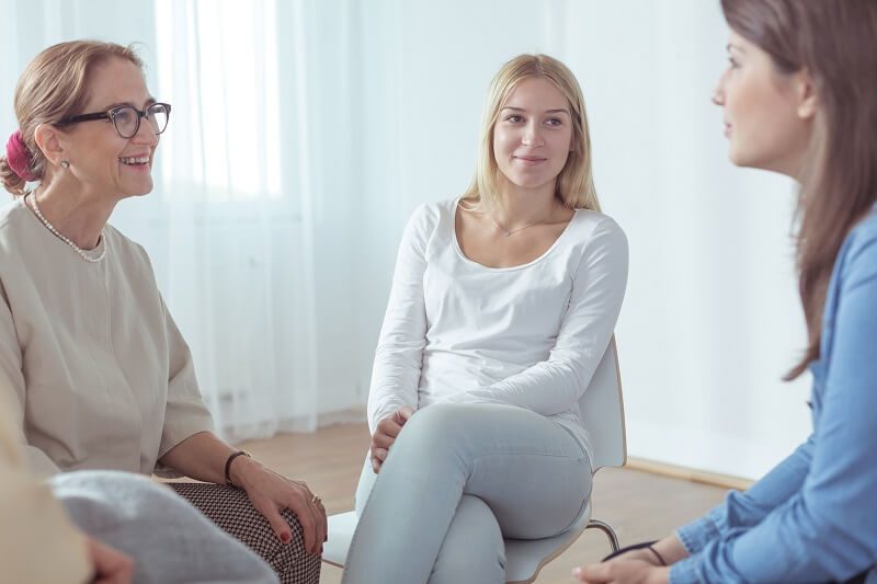 Terapia grupowa Poznań: trzy osoby rozmawiają w czasie spotkania