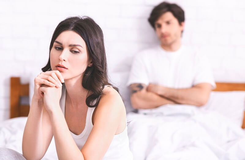 Para cierpiąca na zaburzenia seksualne siedzi na łóżku