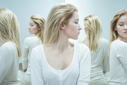 Kobieta z dysmorfofobią patrzy na siebie w lustrze