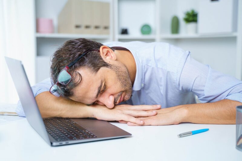 mężczyzna z narkolepsiją śpi w pracy